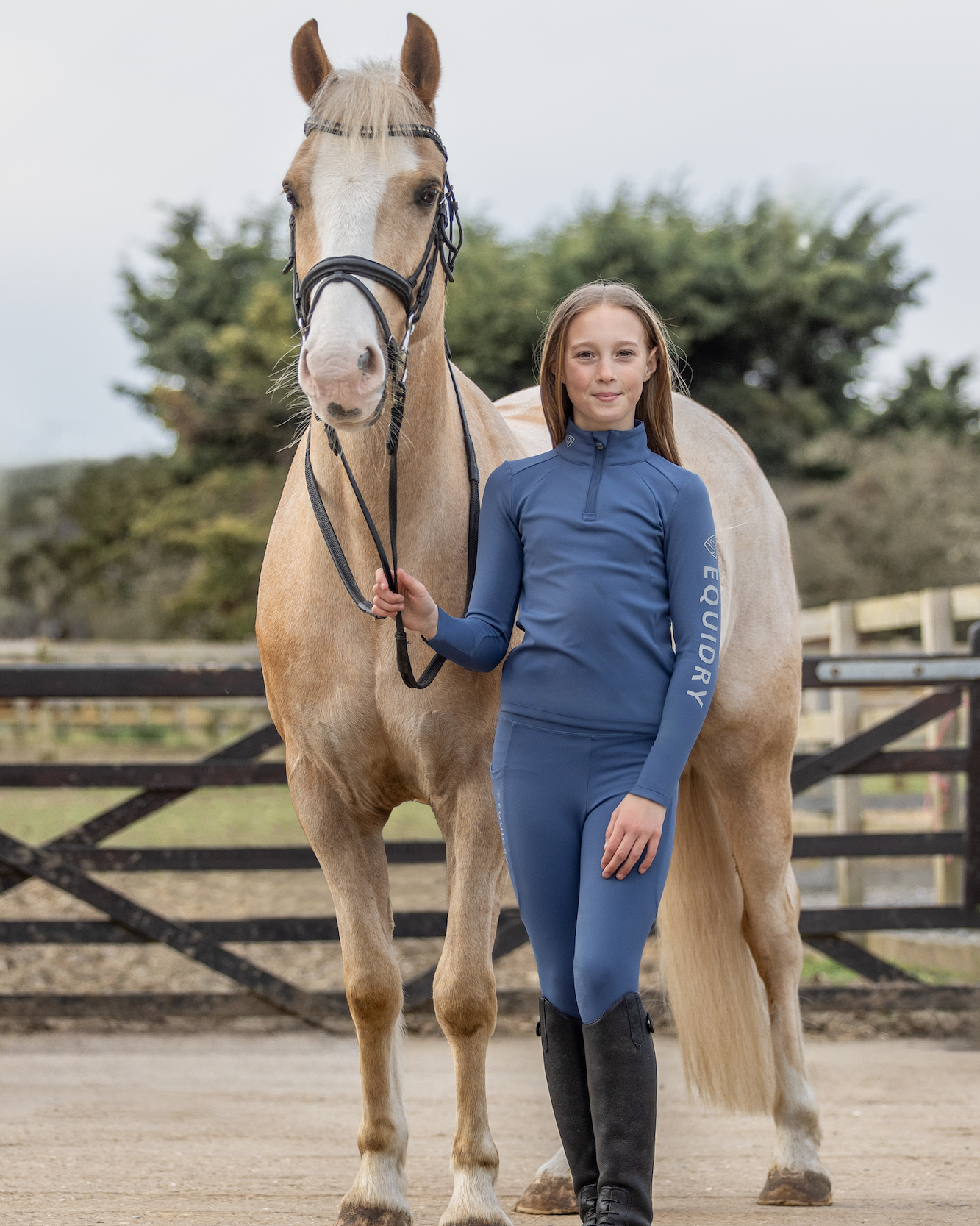 Girl in Equidry steel blue knee grip equestrian leggings standing with horse. #equestrianfashion #ridingleggings #equidry
