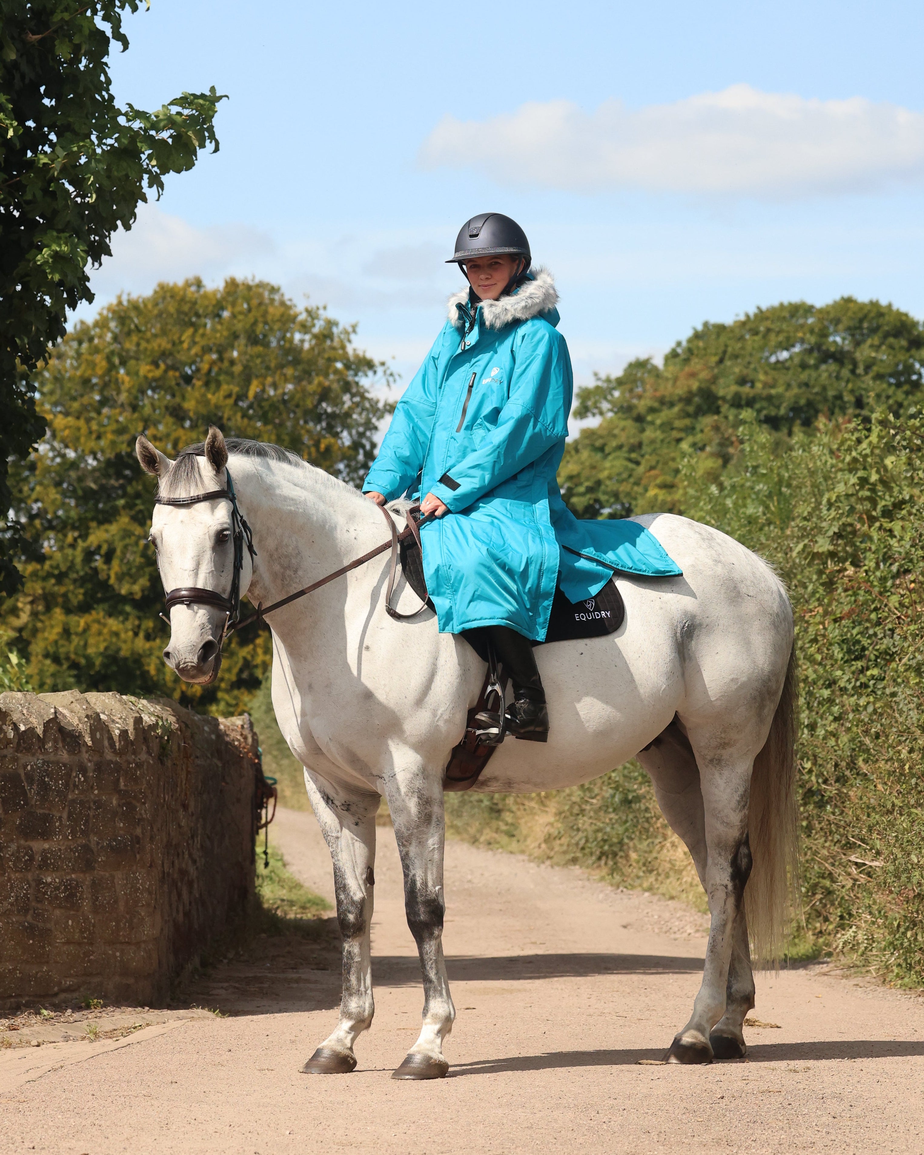 EQUIDRY Evolution Lux Women's Warm Waterproof Winter Horse Riding Coat Thick Fleece Lining with Faux Fur Trim Hood rider on horse side view