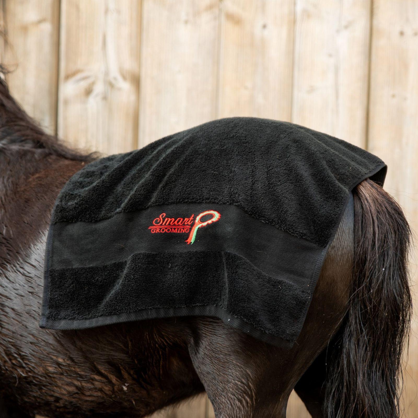 Horse getting dried with Smart Grooming Dry Off Towel from Equiflair. Absorbent cotton towel drying a horse's back.
