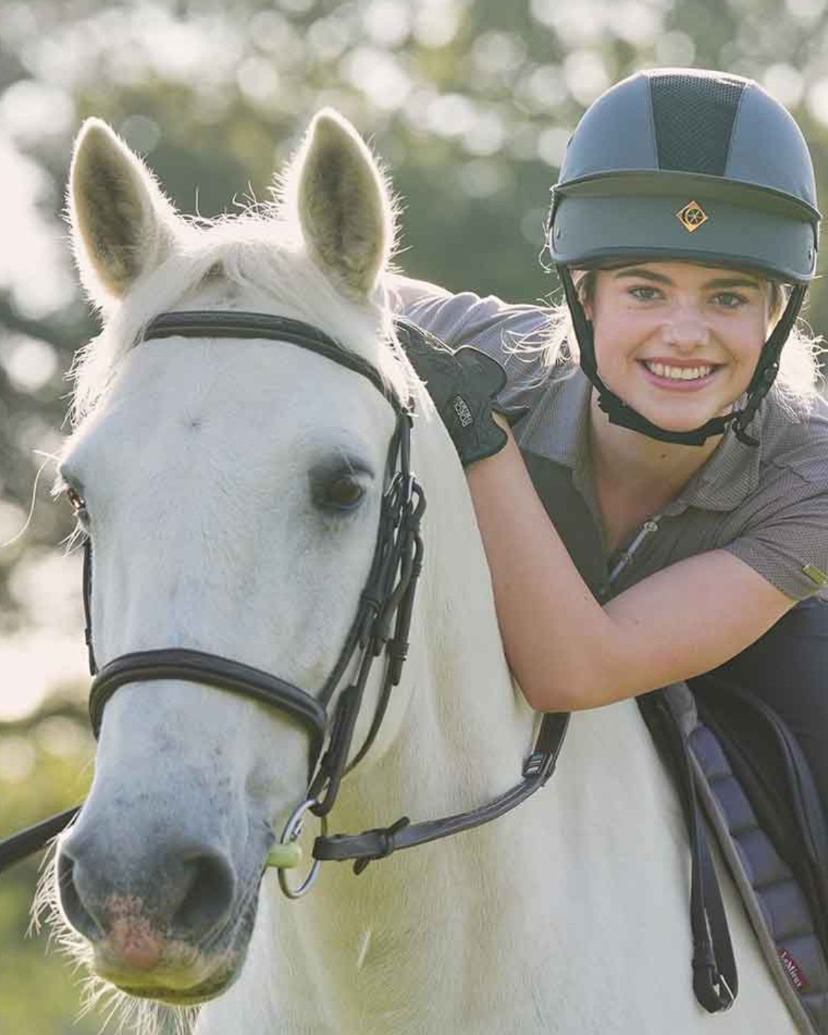Woman wearing a Charles Owen Esme MS1 Pro riding helmet in Graphite/Rose Gold with horse. #Equestrian #ThisEsme