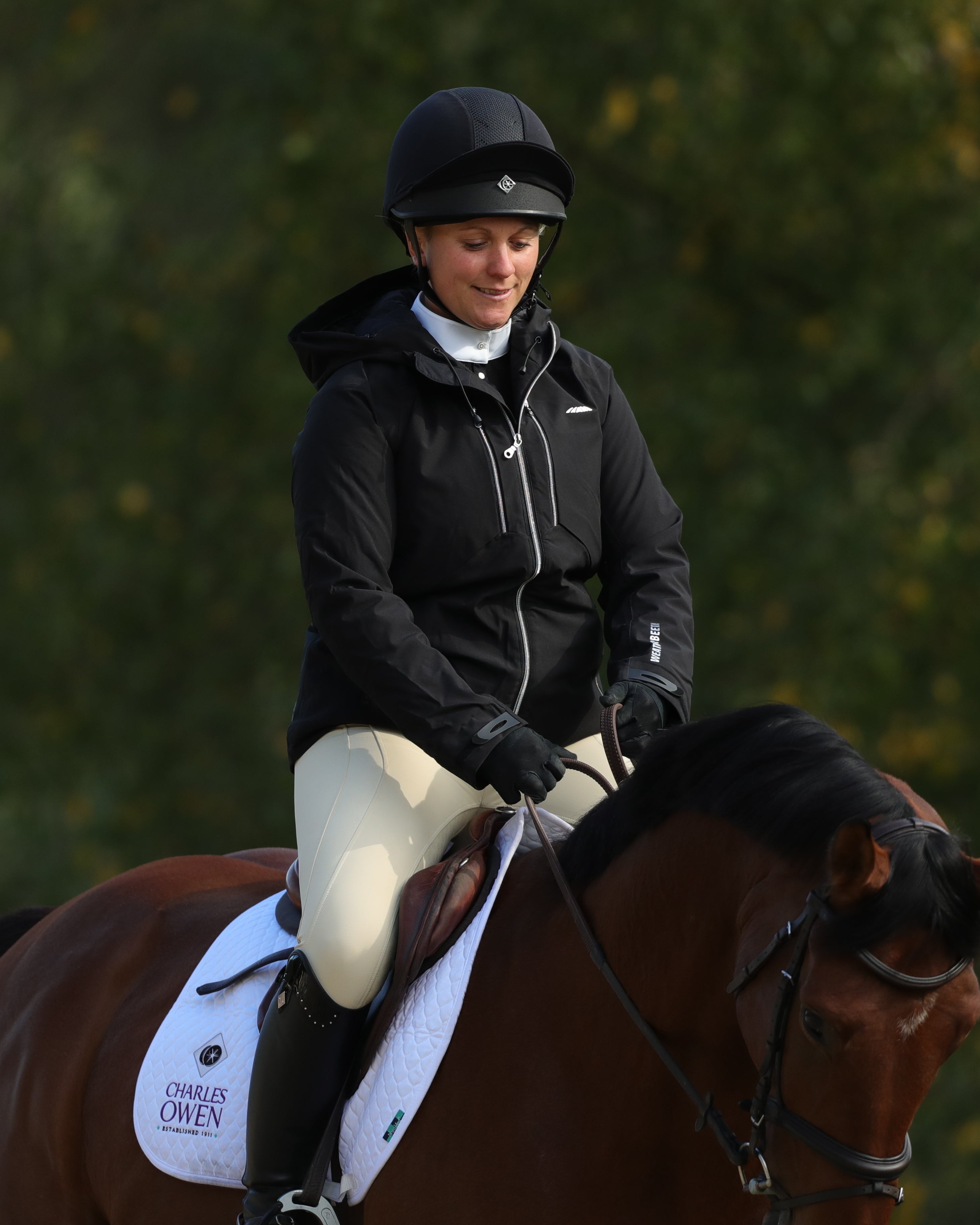 Equestrian rider wearing Charles Owen 4 Star jockey helmet on horseback. Secure and stylish head protection for horse riding.
