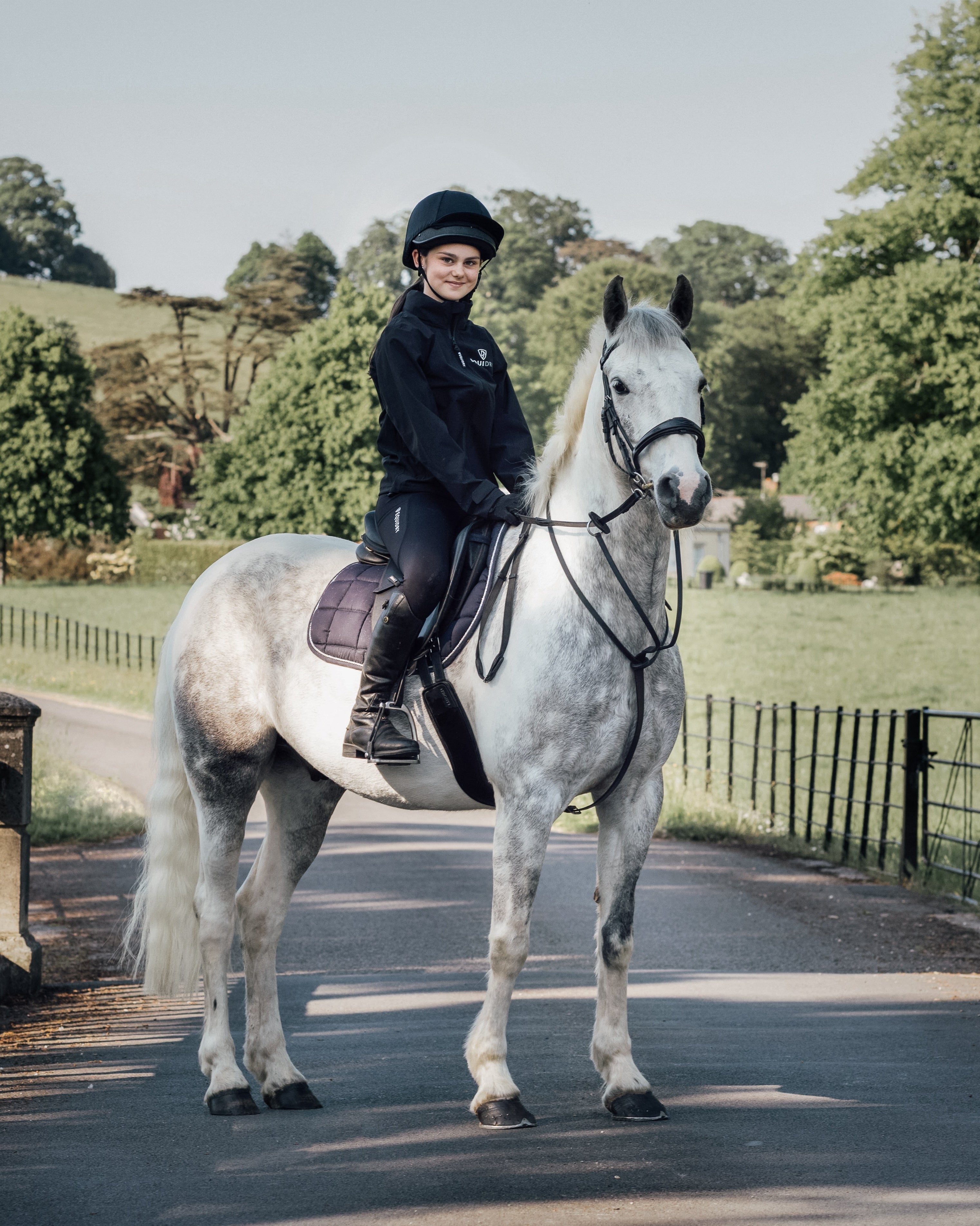 Equestrian Child Riding Horse Wearing EQUIDRY NIMBUS Pack Away Black Jacket From Equiflair