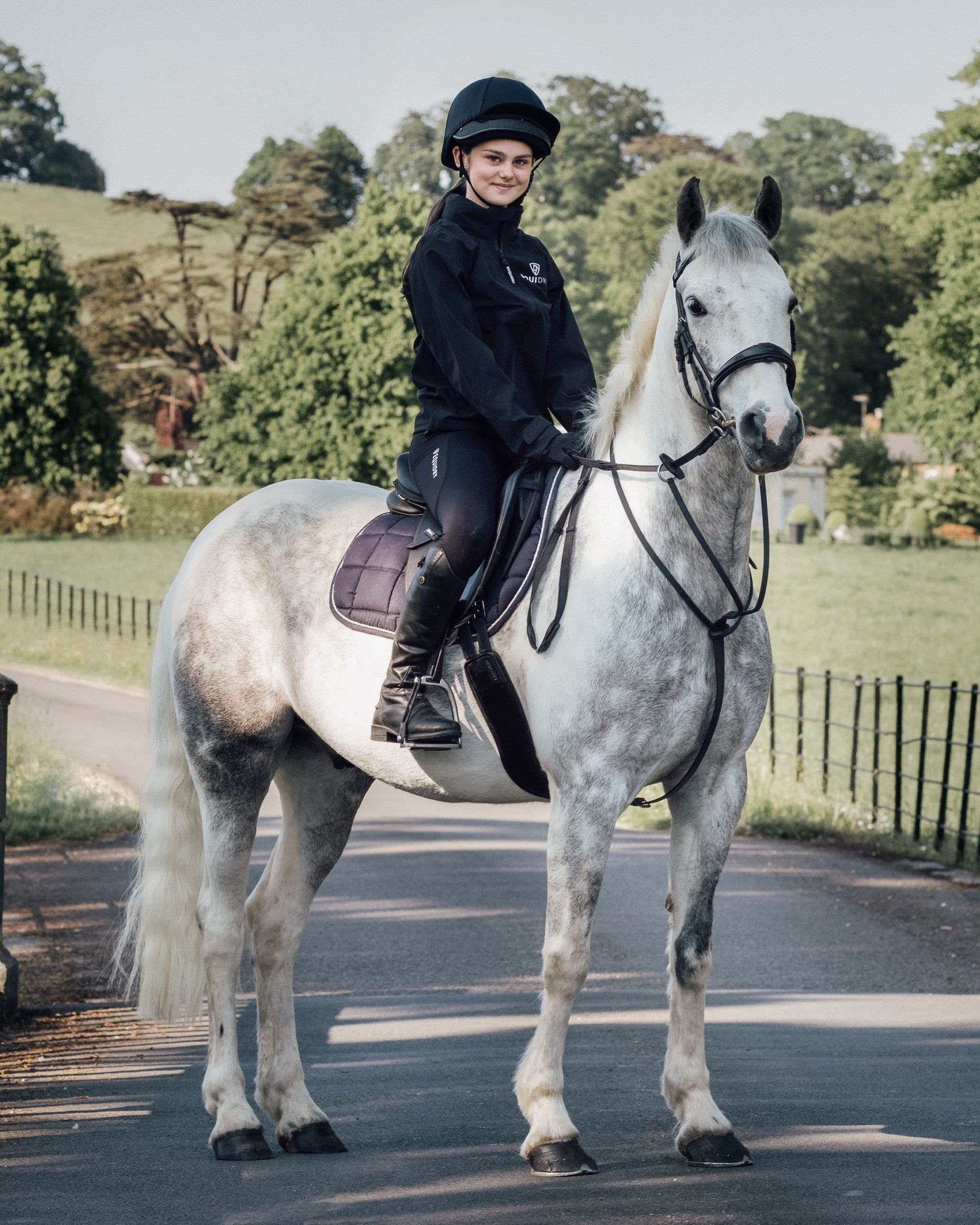 Young equestrian rider on gray horse wearing Equidry riding leggings by Equiflair, equestrian apparel, outdoor riding