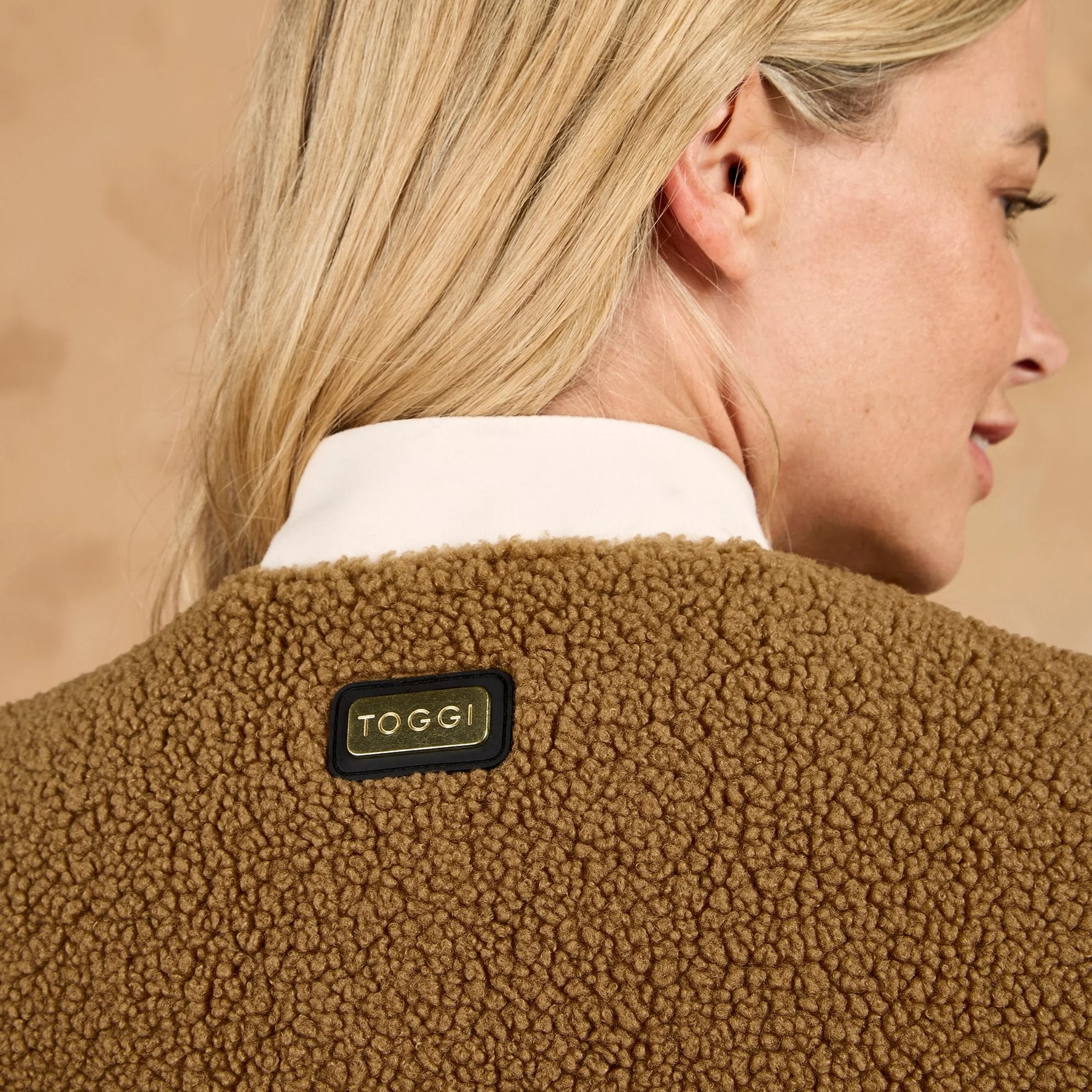 Woman wearing brown TOGGI reversible fleece gilet with quilted detail and metallic TOGGI badge