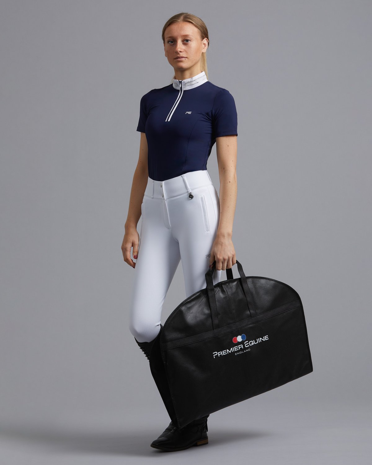 Equestrian Woman Holding Premier Equine Show Jacket Garment Bag, Black. Stylish equestrian storage solution.