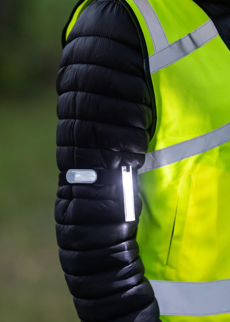 Equestrian safety: Rider wearing Woof Wear high-visibility 3-in-1 LED arm light for horse riding. Rechargeable, visible, safe.