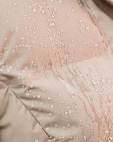 EQUIDRY Thora Waterproof Riding Puffer, Sand Color, Women's. Water droplets show water resistance. Close-up view.