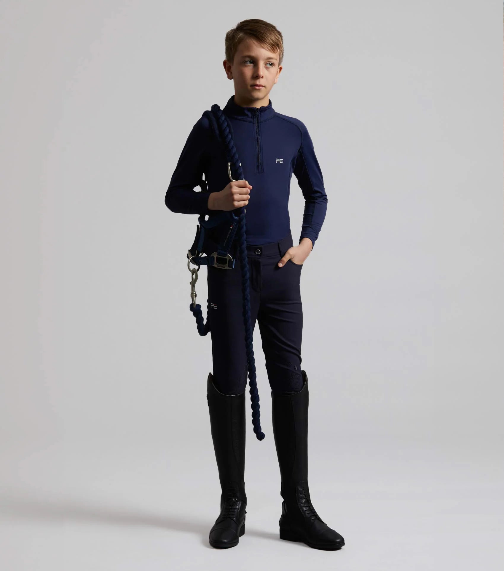 PREMIER EQUINE Derby Boys Riding Breeches Navy: Boy equestrian apparel, riding boots, holding rope, stable wear, riding pants