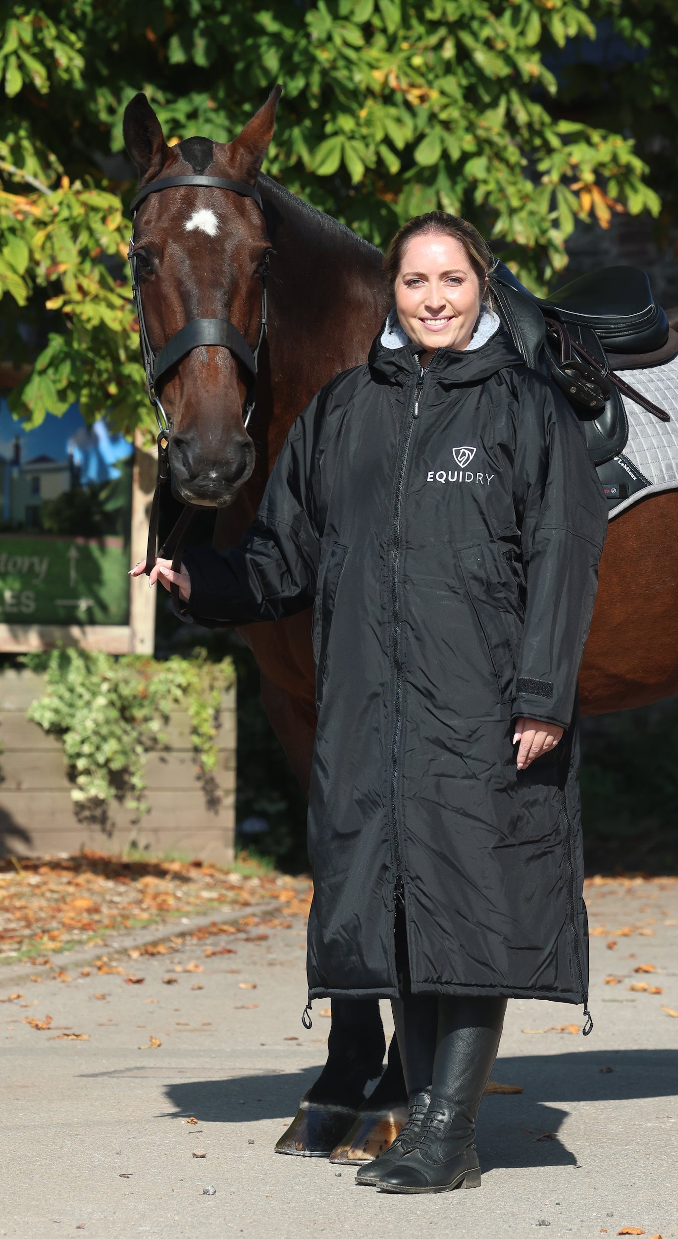 EQUIDRY waterproof horse riding raincoat All Rounder Original thick fleece Women's black/grey rider stood with horse