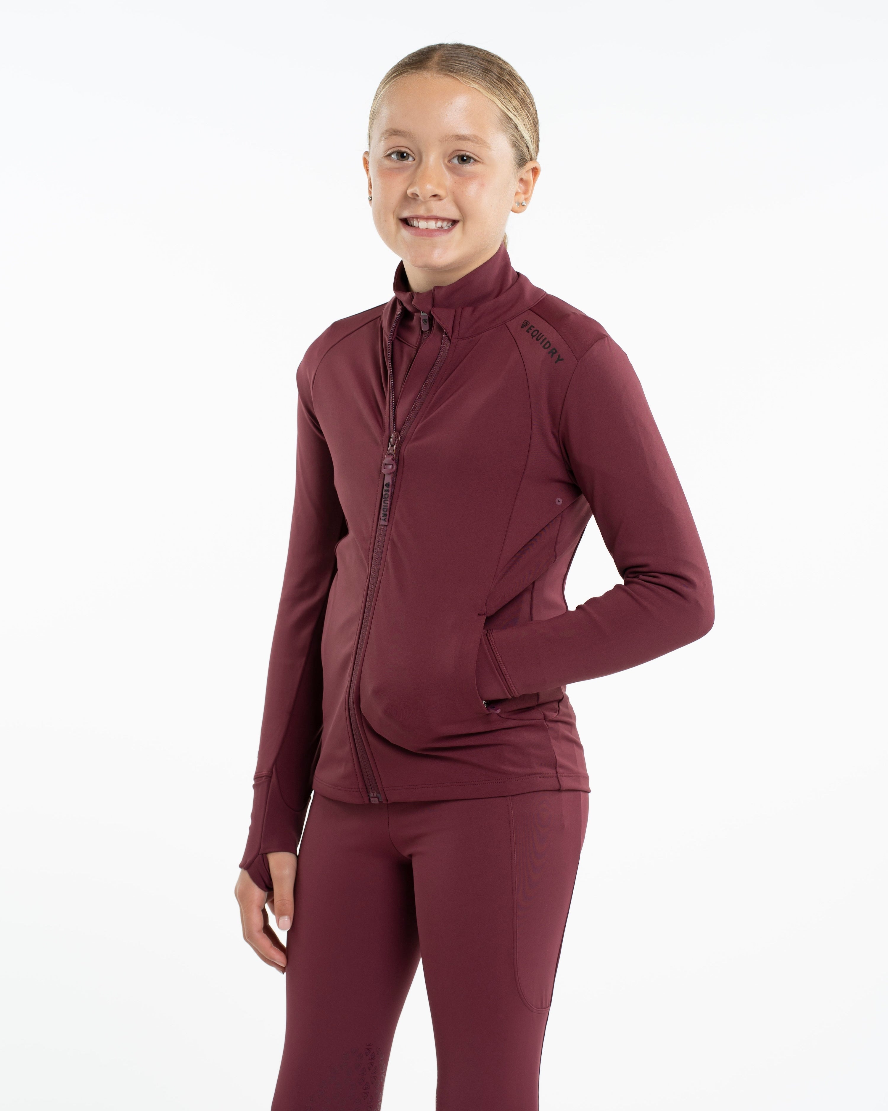 Girl wearing EQUIDRY CHILDREN'S WATER REPELLENT ZIP UP TOP PLUM/BLACK - Water repellent and Stylish children's equestrian apparel