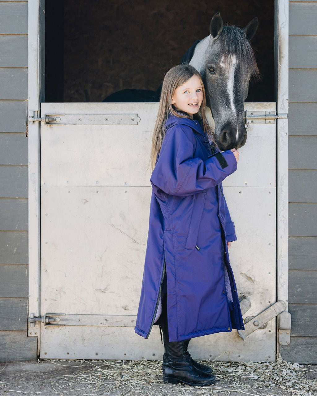 Girl in Purple Equidry Riding Coat with Horse at Equiflair - Child Equestrian Fashion, Warm, Waterproof Coat