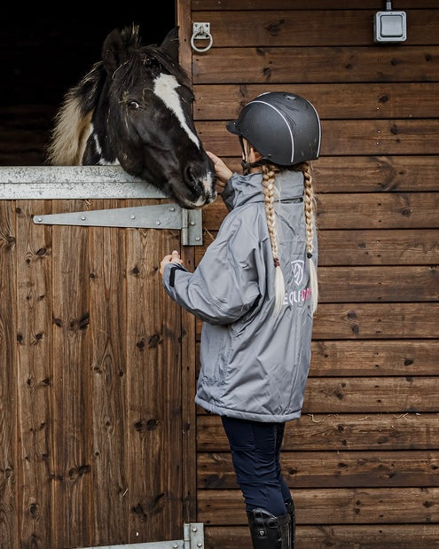 Shortie Child's Oversized Short Waterproof blouson style Riding Jacket Thin Fleece Lining Stowaway Hood in charcoal/penelope pink back view with horse