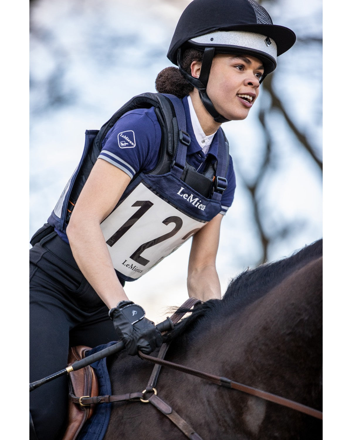 LeMieux Eventing Bib in Navy: Horse rider wearing competition bib number 12. Equestrian event accessory from Equiflair.