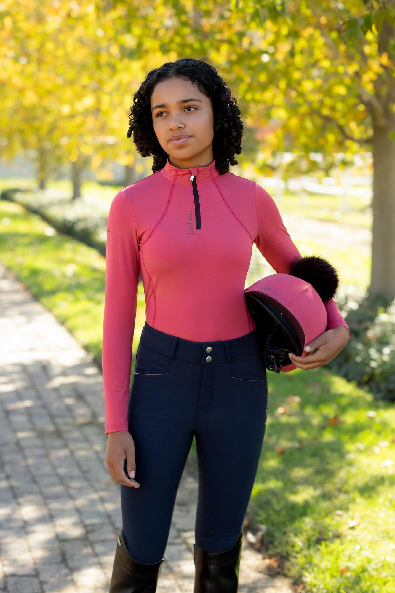 LEMIEUX YOUNG RIDER CLASSIQUE BASE LAYER CRANBERRY - girl holding helmet, riding apparel