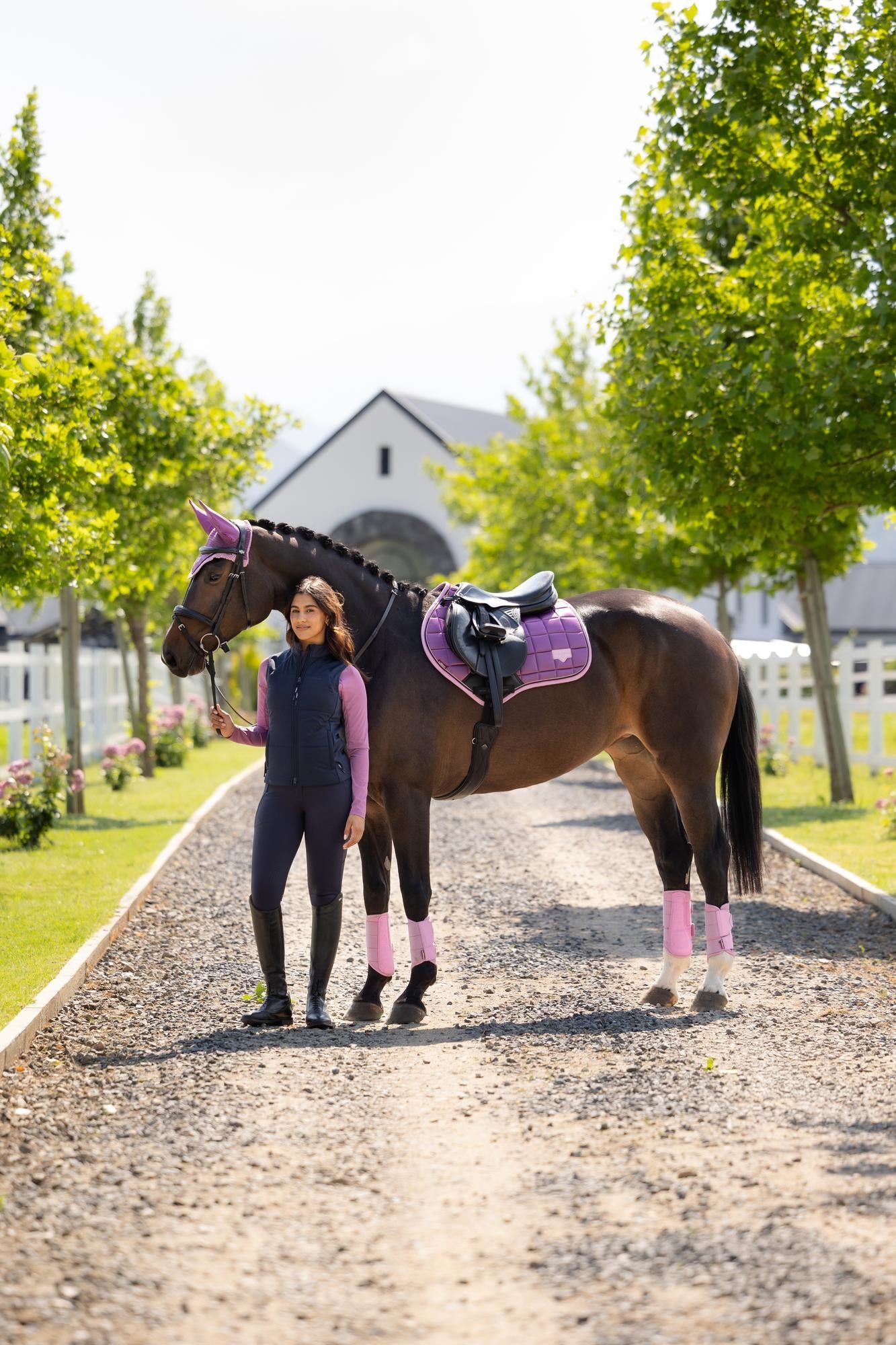 Woman with horse wearing LEMIEUX LOIRE CLASSIC CLOSE CONTACT SQUARE MALLOW saddle pad, ear bonnet, & leg wraps. #EquineStyle