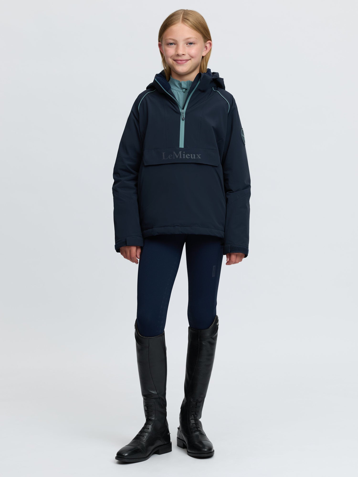 LeMieux Young Rider navy waterproof anorak with hood and kangaroo pocket for equestrian activities.
