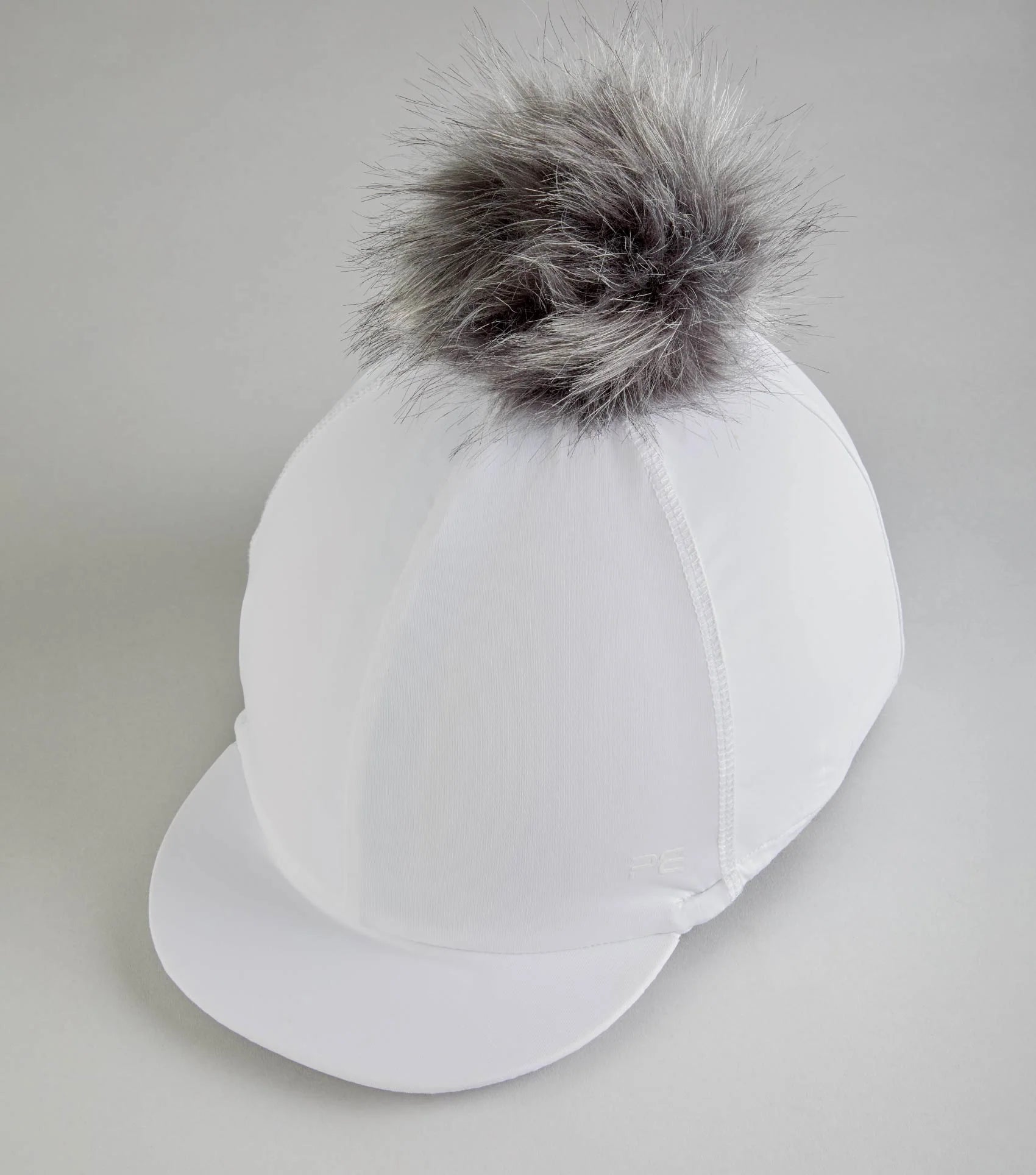 White Premier Equine equestrian helmet cover with faux fur pom pom. Stylish riding hat silk for women. Secure fit, crease-free.