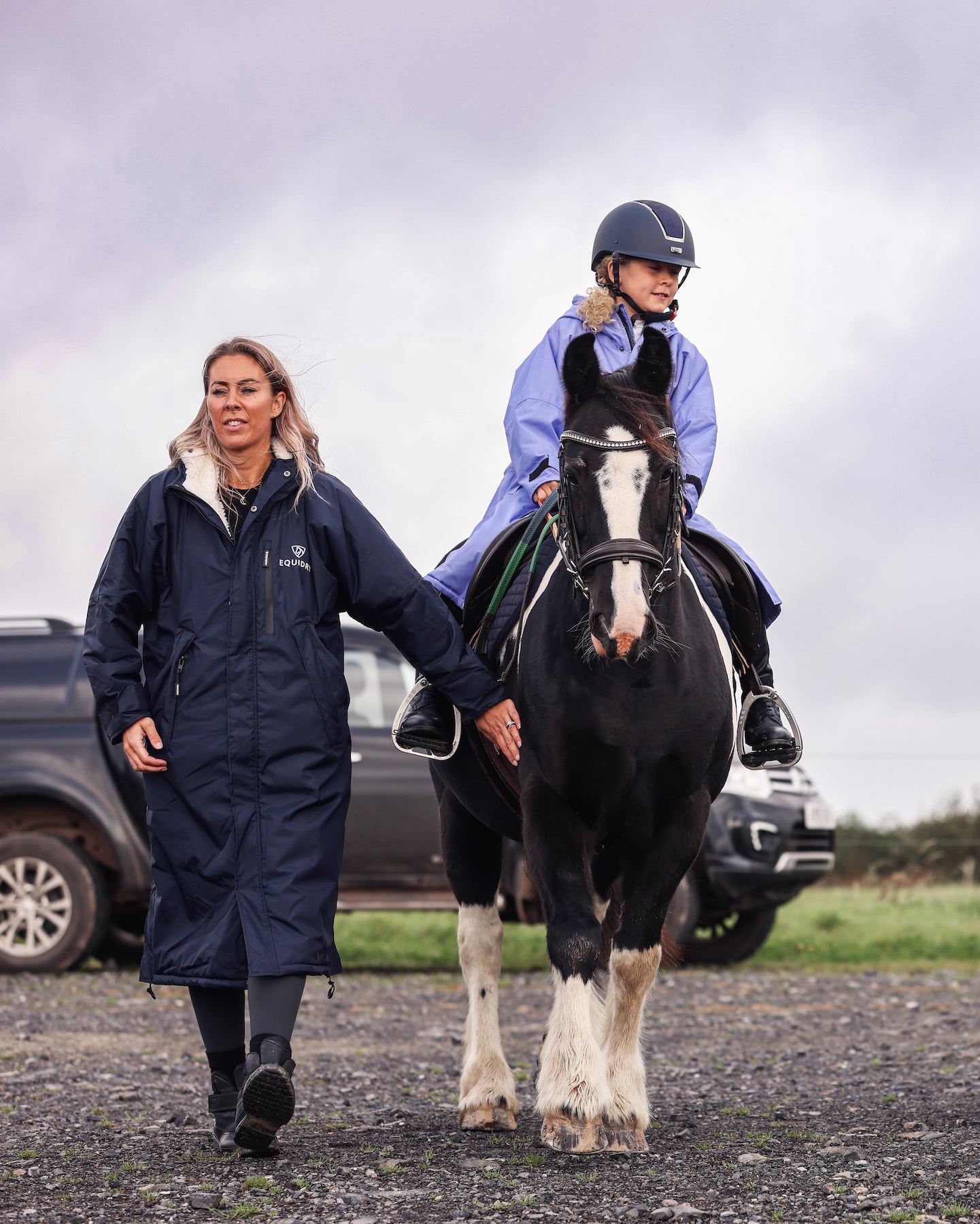 EQUIDRY women's long waterproof horse riding coat in Dark Navy/Cream group image of girls walking on horseback to have riding lesson