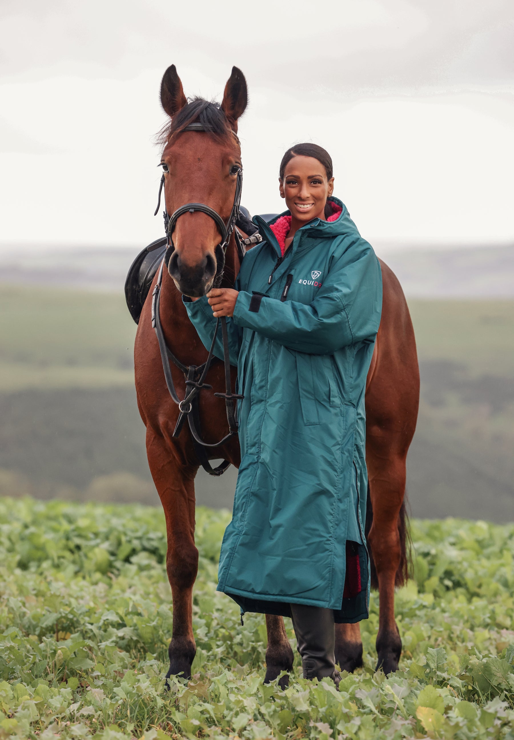Equidry: Teal Waterproof Horse Riding Coat with Woman & Horse. Rider in Equidry Evolution Teal/Pink Coat.