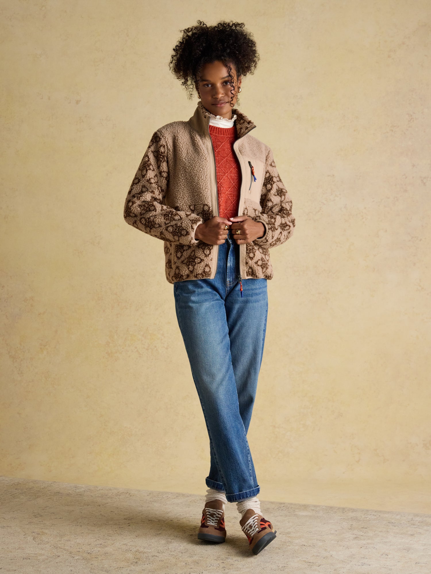 Joules Lottie Neutral Icon Print Borg Fleece with Zip Fastening Outfit: Model in jeans, sweater, and Joules fleece jacket.