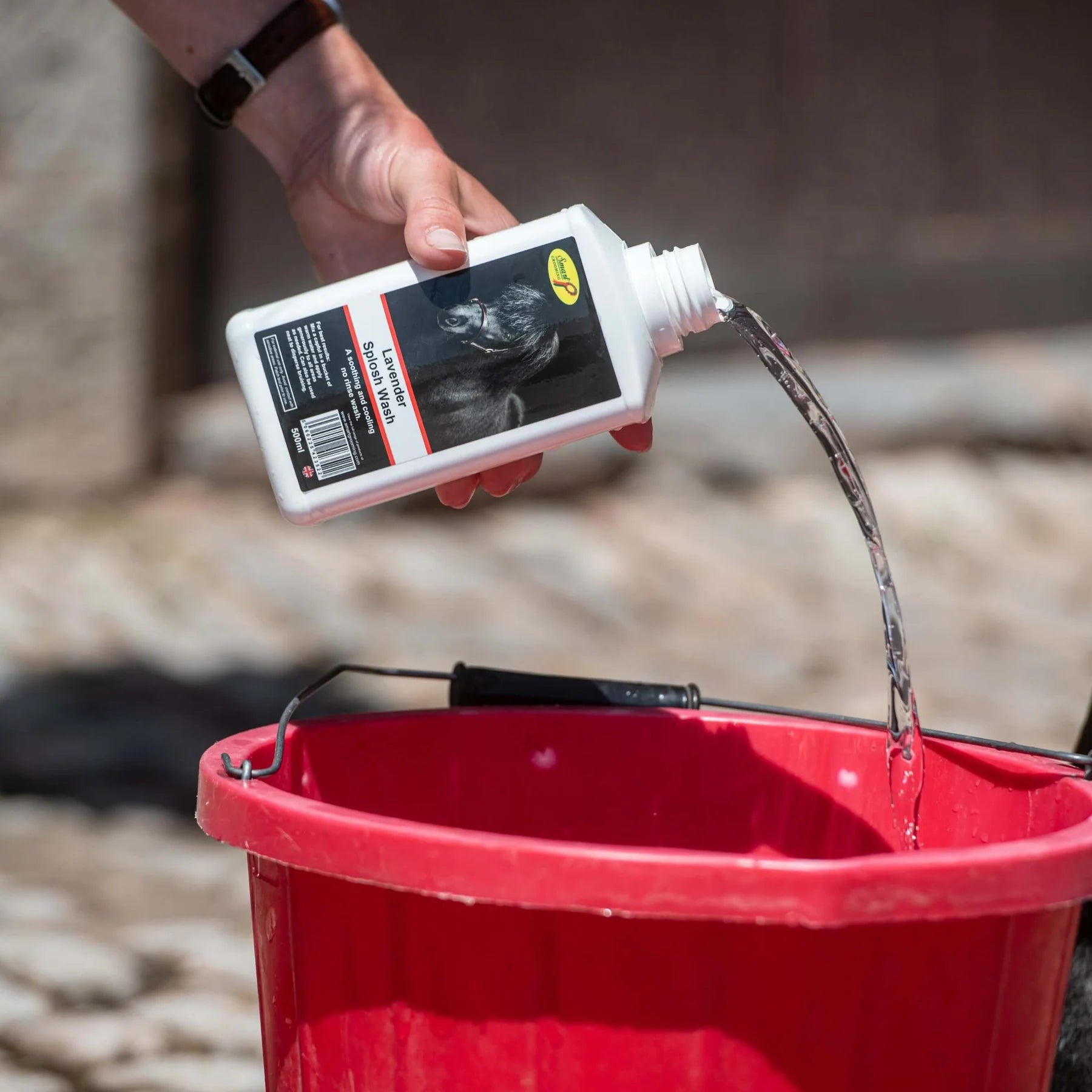 Smart Grooming Lavender Splosh Wash being poured into a bucket. Horse wash product for cooling & soothing.