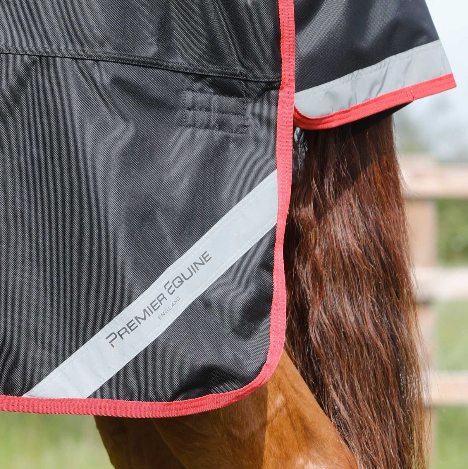 Close-up: Premier Equine Titan 450g Black Turnout Rug. Horse Rug with Reflective Trim & Red Edging. Equiflair.