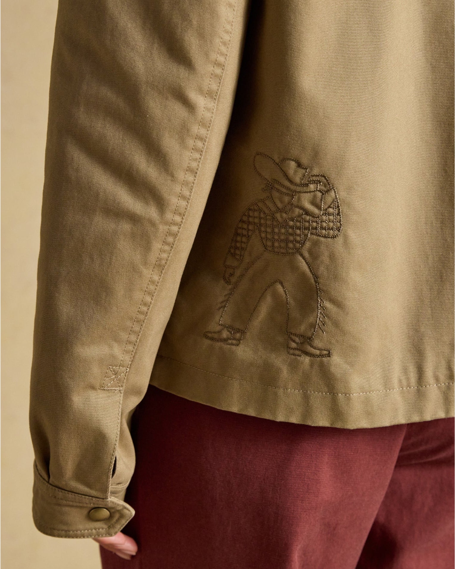 Joules women's tan barn jacket with embroidered cowboy detail on back
