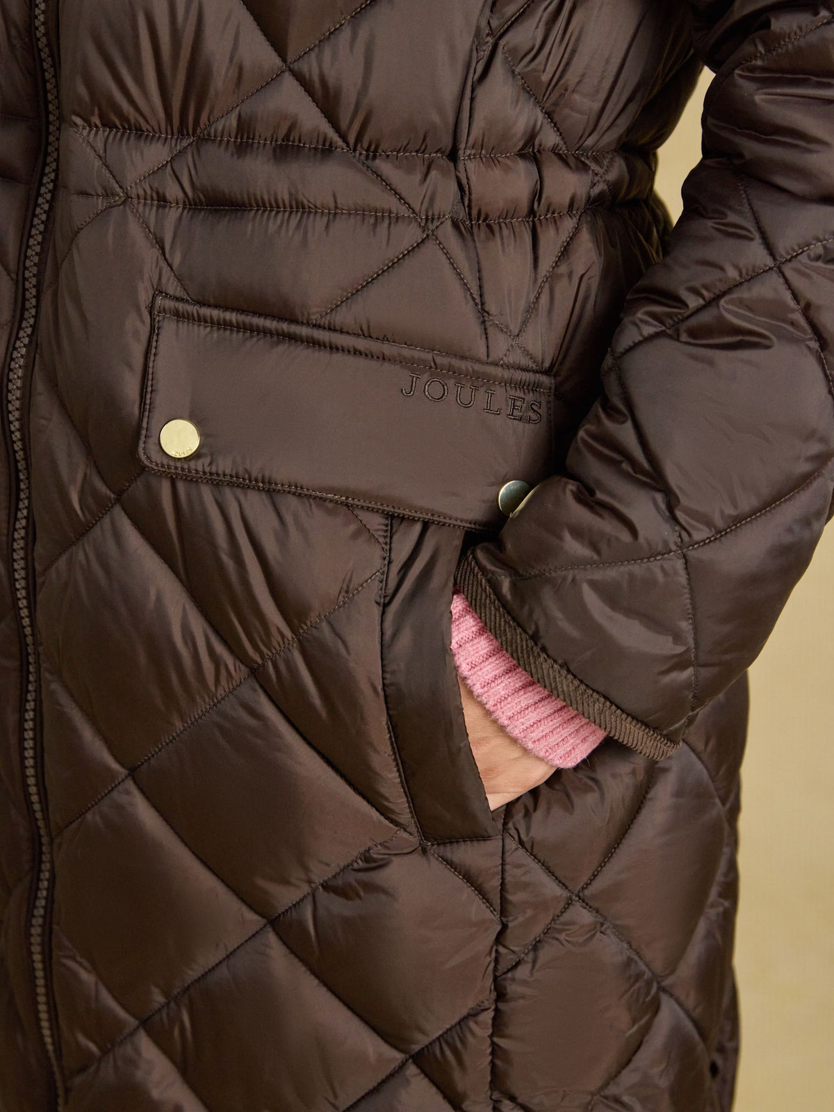Brown Joules women's quilted coat with logo detail and hand in pocket