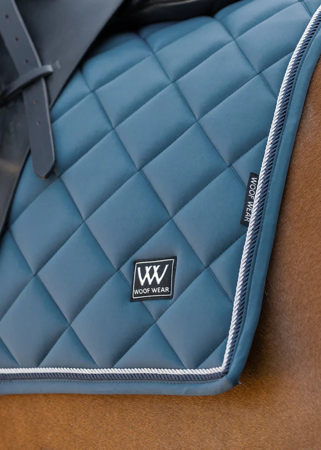 Woof Wear Vision Aura Dressage Saddle Pad - Petrol Blue: Close-up of quilted pad with logo detail for comfort and fit.