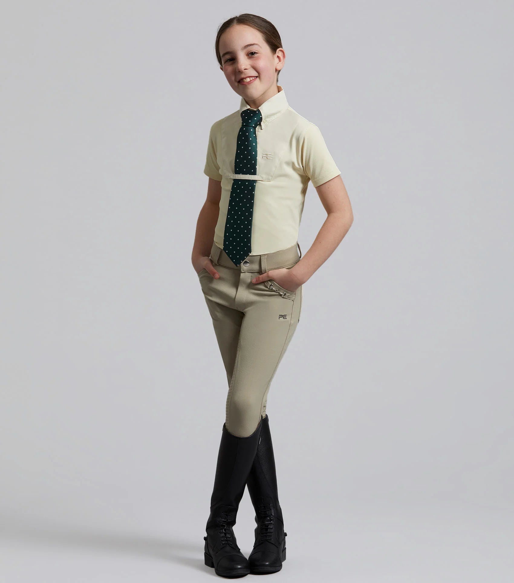 Girl in Premier Equine Brava Beige Riding Breeches with full seat gel, Equestrian Competition Apparel