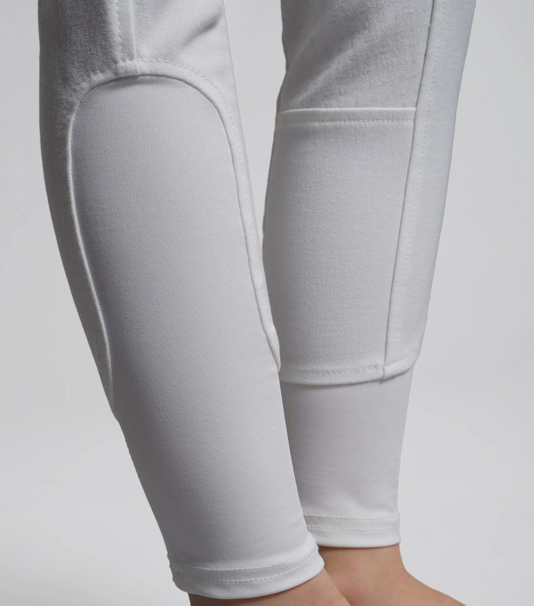 White riding breeches with gel seat, girls competition breeches, Premier Equine Brava. Equestrian riding apparel close-up.