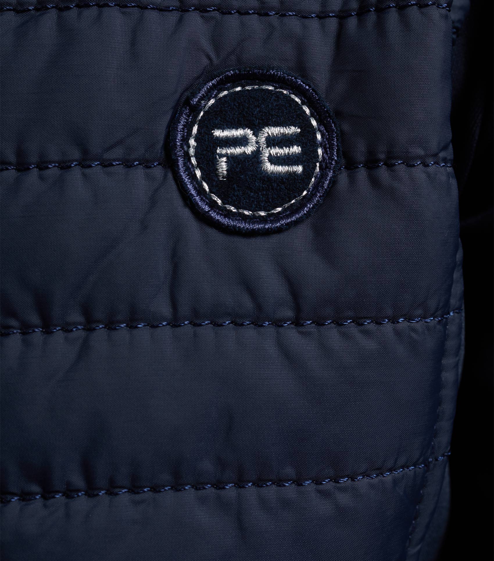 Premier Equine Mini Elena Girl's Hybrid Navy Riding Jacket. Quilted design with 'PE' logo. Stylish & functional equestrian wear.