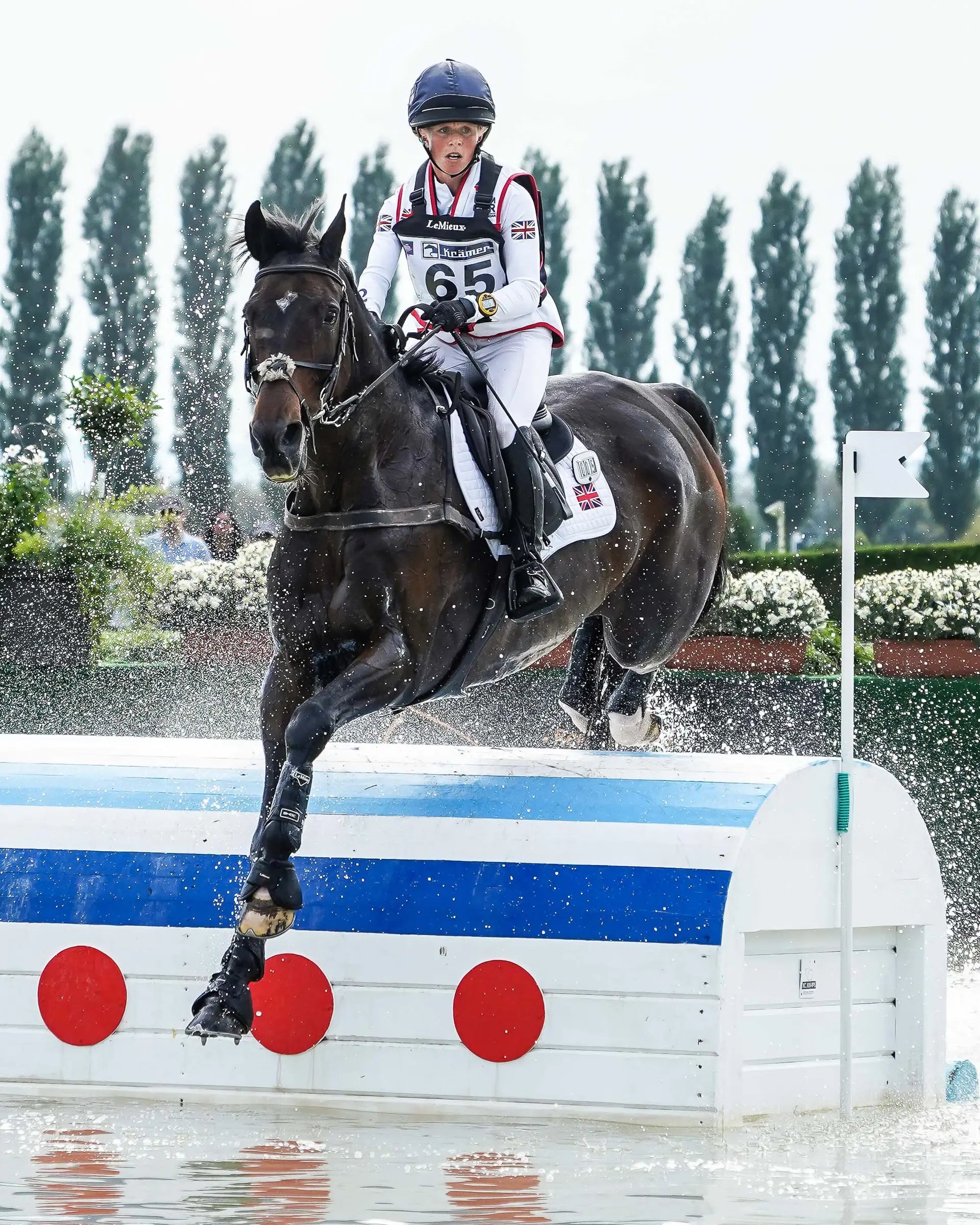 British Eventing: Horse and Rider Jumping Water Obstacle. Cross Country Equestrian Sport Competition.
