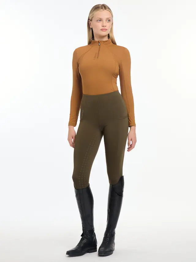 Equestrian Style: Women's Ginger LeMieux Base Layer Riding Gear in Olive Leggings and Black Boots