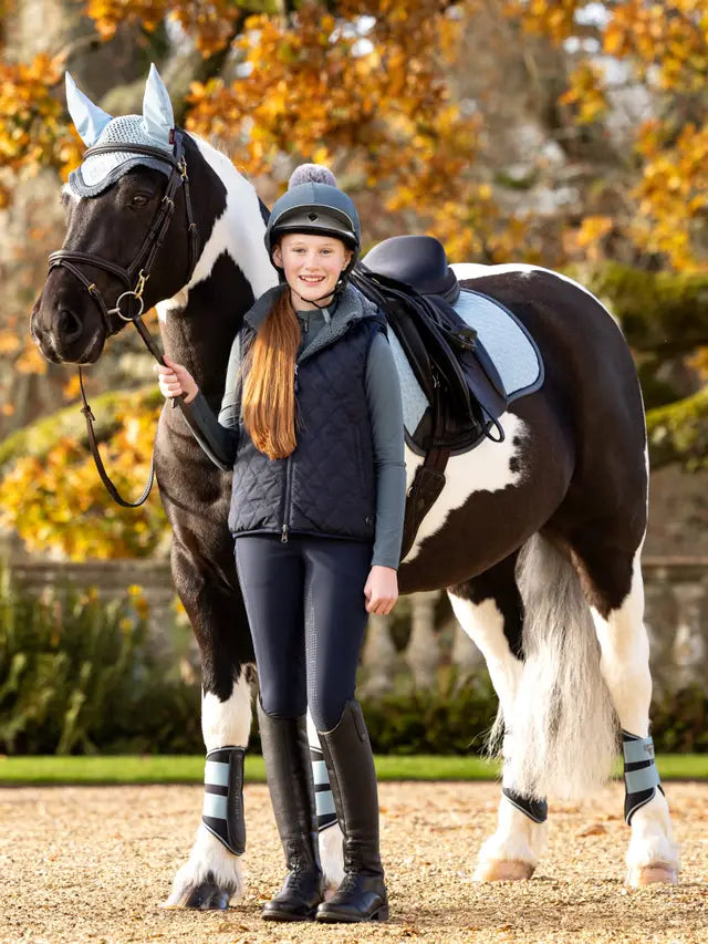 Girl Horse Riding with LEMIEUX Gilet: Equestrian Apparel for Young Riders. Horse and rider posing. Equiflair Store.
