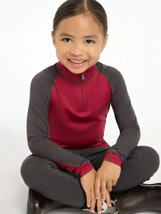 LeMieux Mini Base Layer - Ember. Girl wearing equestrian riding shirt for kids, riding apparel.