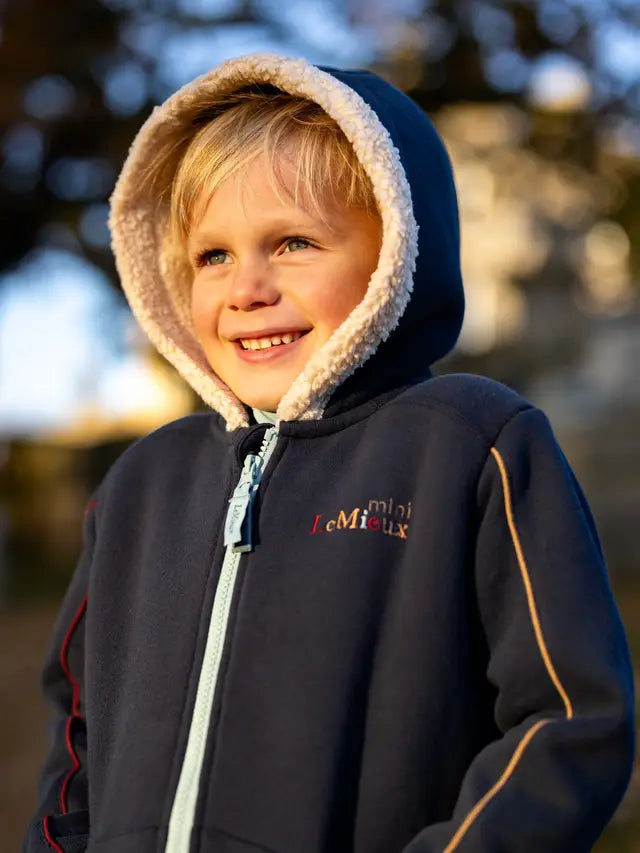 LeMieux Mini Charlie Lined Hoodie Navy - Boy in Hooded Jacket Smiling. Cozy kids equestrian fashion from Equiflair!