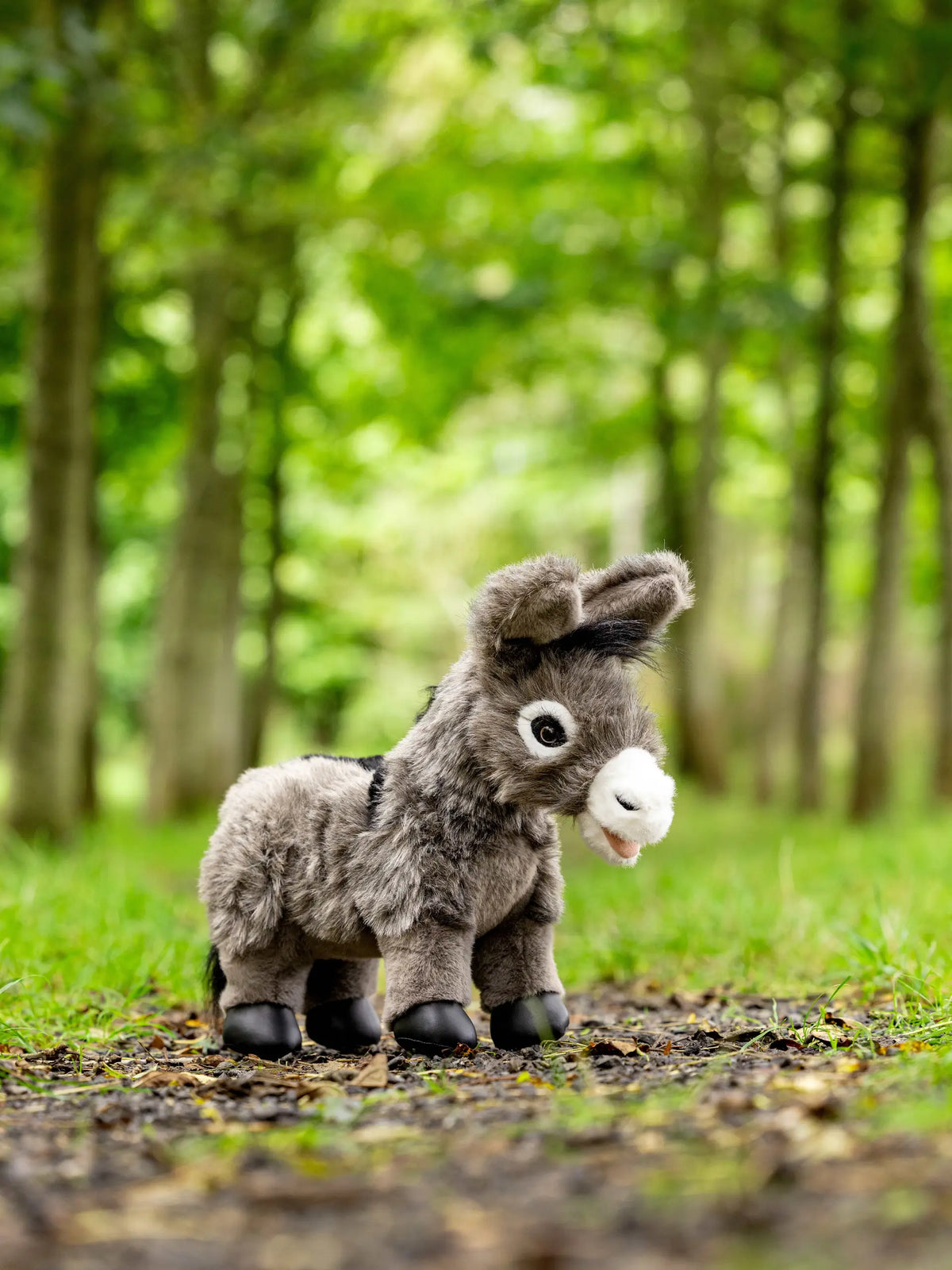 LeMieux Toy Donkey Daphne, a realistic plush toy with long ears in a woodland setting.