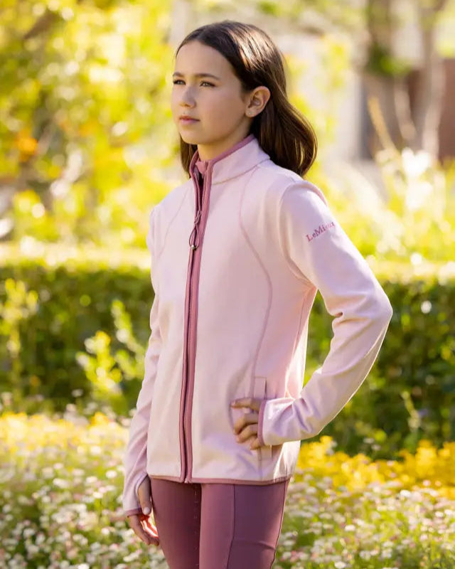 LEMIEUX Young Rider Felicity Fleece Zip Through Blossom - Girl wearing jacket standing outdoors.