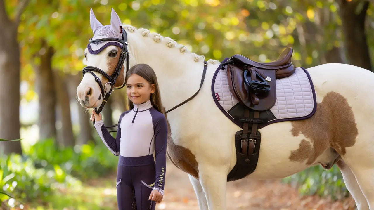 LeMieux Mini Suede Lilac Saddle Pad on Pony with Girl. Equiflair Equestrian Apparel.