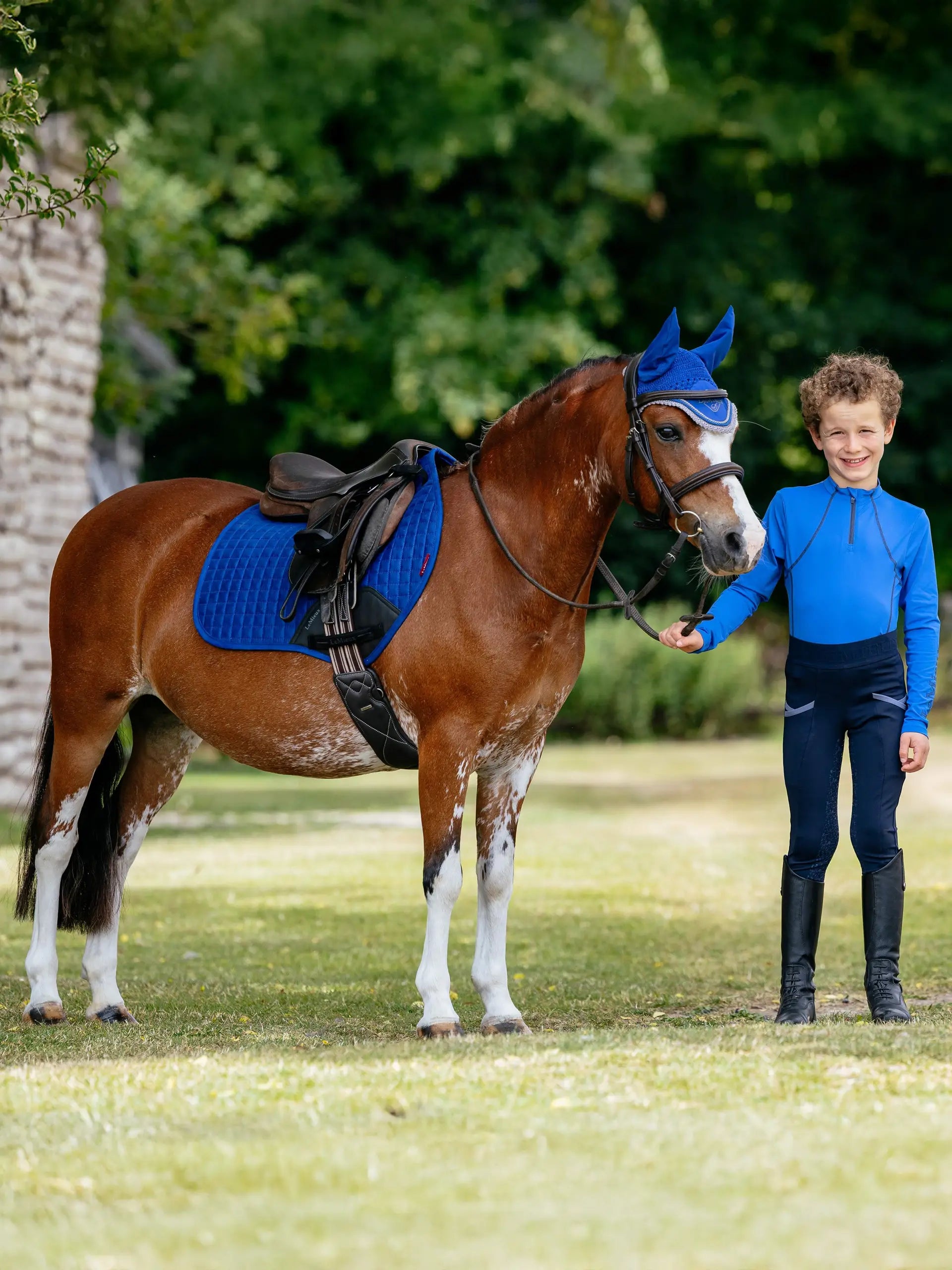 Child riding pony with LEMIEUX MINI SUEDE CLOSE CONTACT SQUARE BENETTON BLUE saddle pad. Equiflair.