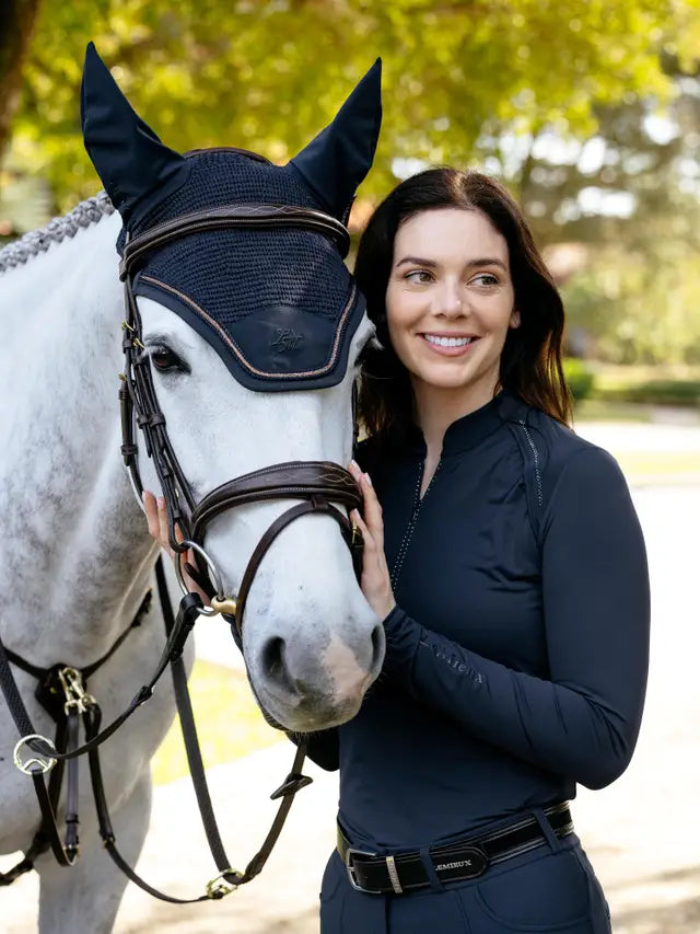 LeMieux Brilliance navy base layer on woman with horse. Equestrian style and performance.