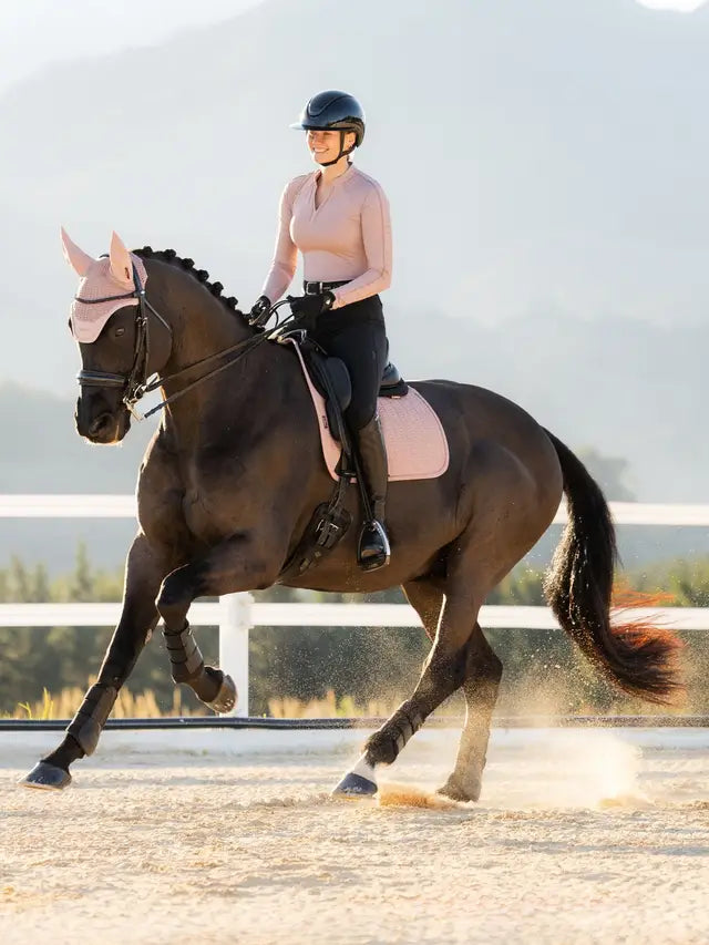 Equestrian rider in pink LeMieux dressage tack, horse training in Wild Rose saddle pad
