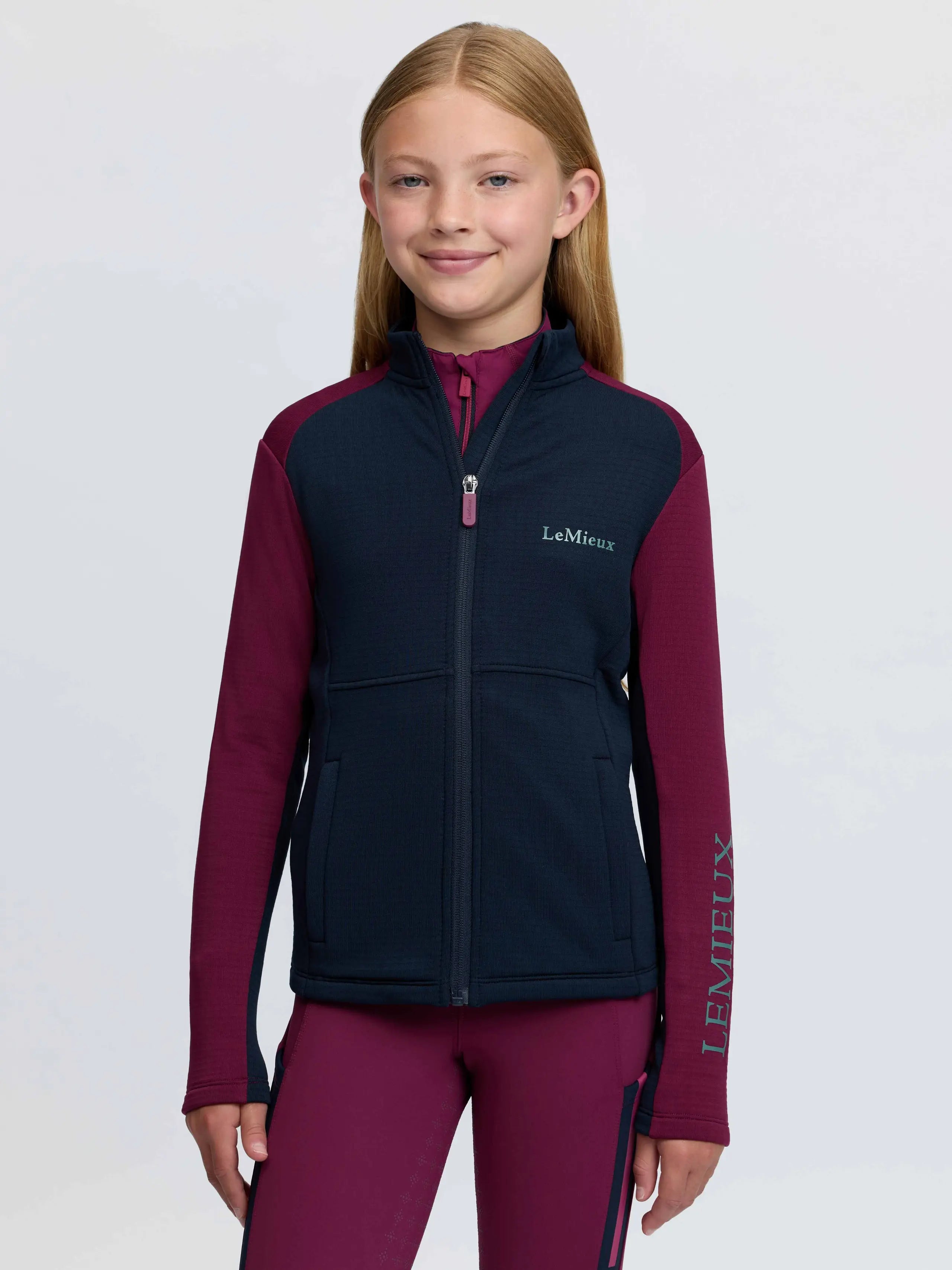 LeMieux young rider Bethany zip through mid layer in blackberry for equestrian activities.