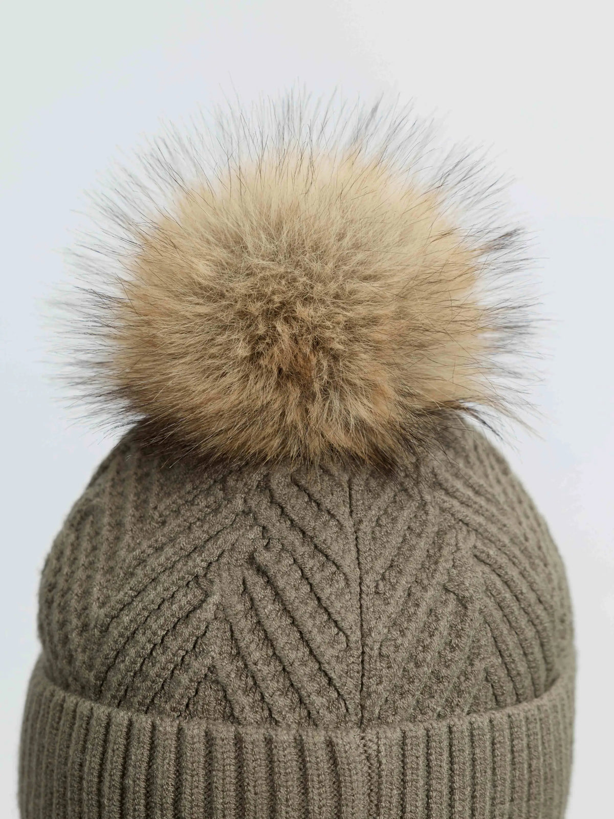 LeMieux Clara Knit Beanie in Willow Green with a fluffy fur pom pom, close-up view.