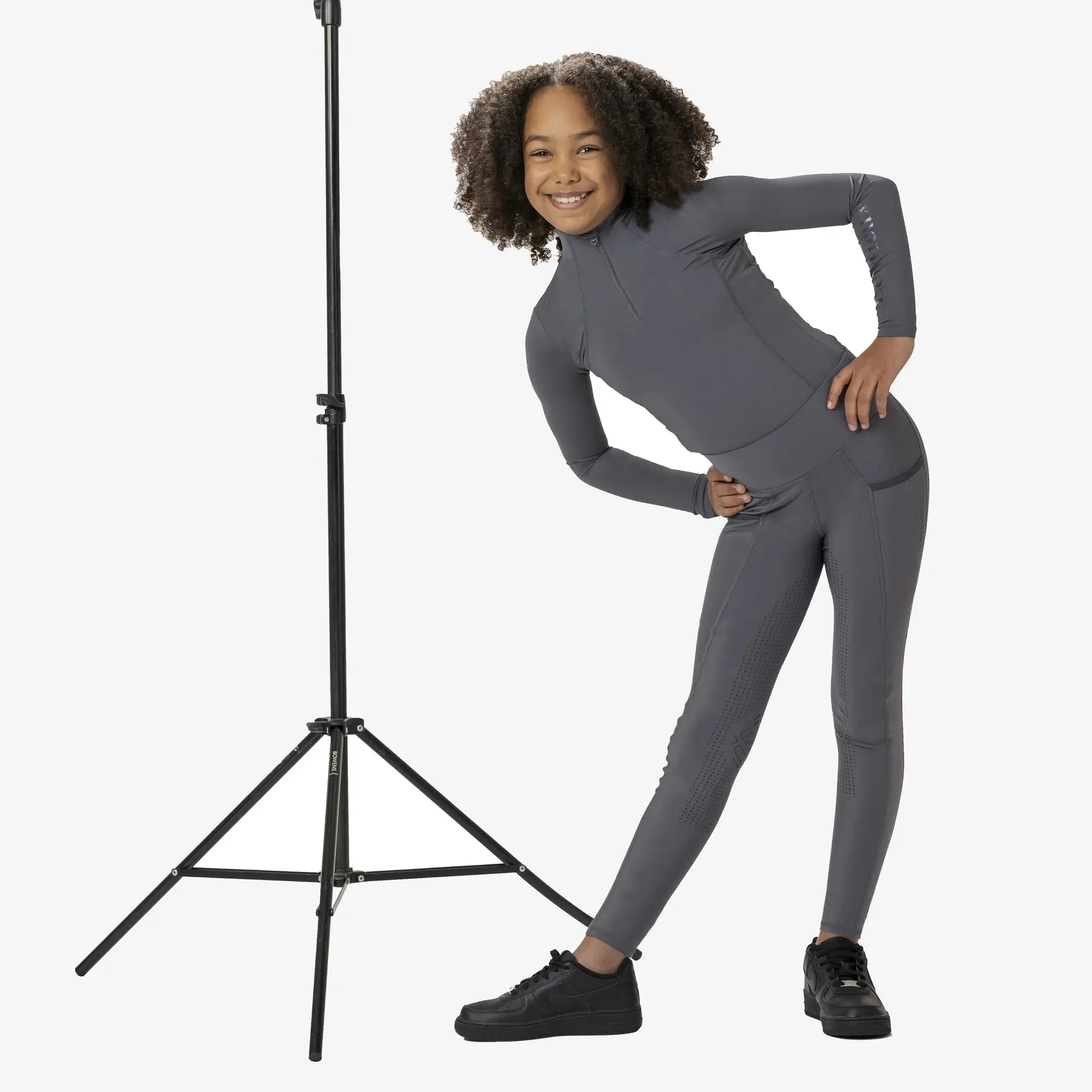LeMieux Young Rider Slate Base Layer. Performance technical riding apparel for young equestrians, posing for Equiflair.