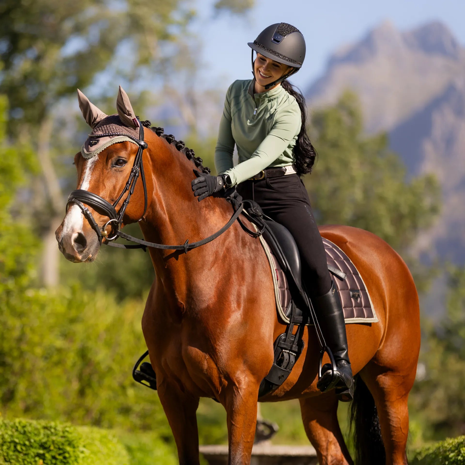 LeMieux Equestrian: Rider in Thyme Mia Mesh Base Layer on Horseback. Stylish Riding Apparel.