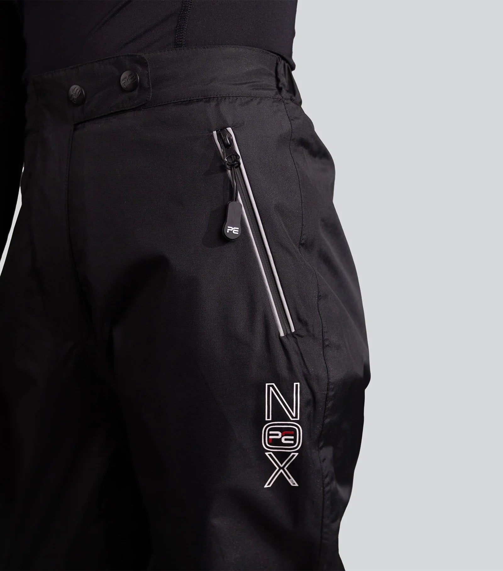 PREMIER EQUINE NOX DUO Waterproof Trousers Black. Equestrian riding apparel with gel seat, zippered pockets, reflective detailing.