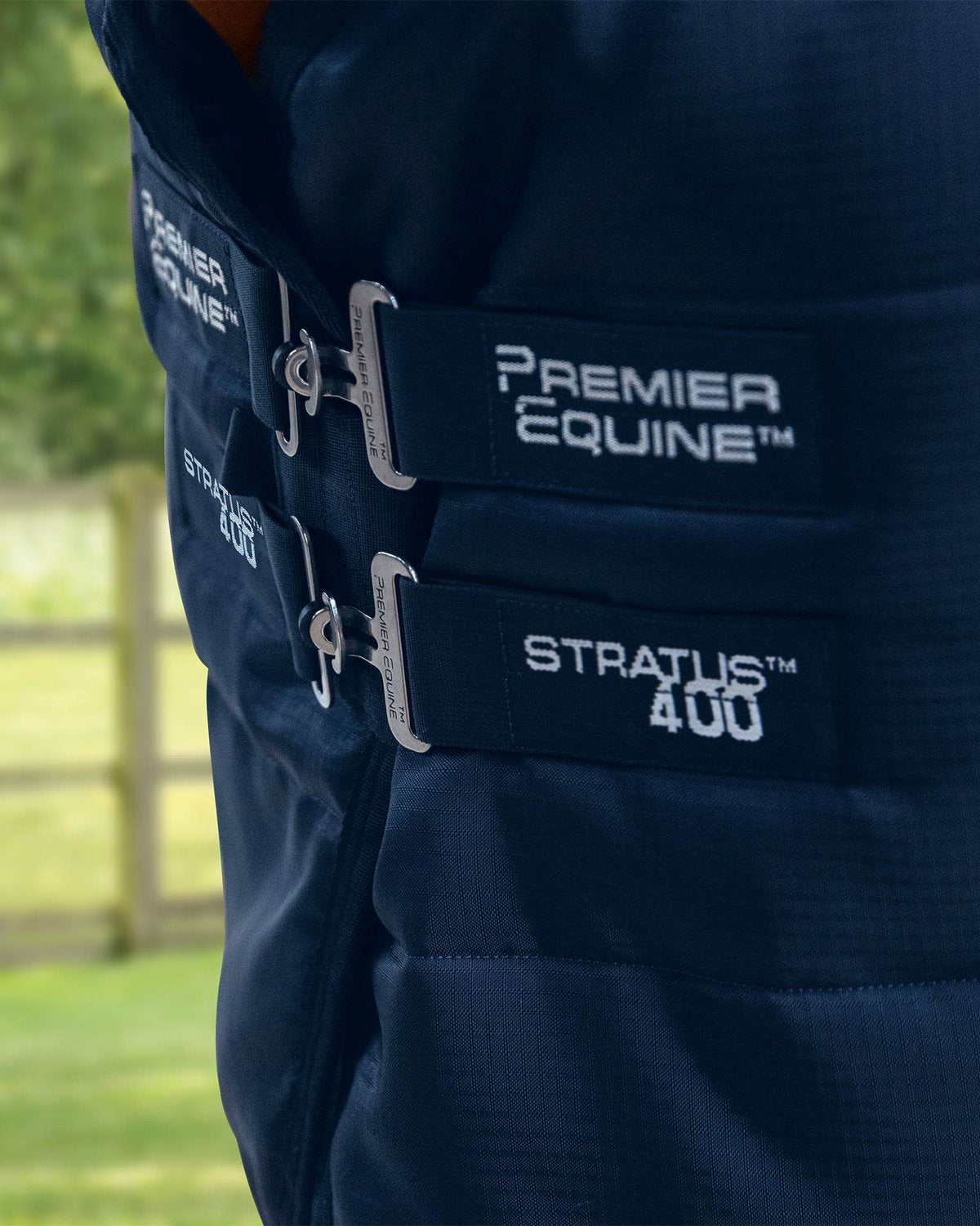 Premier Equine Stratus 400 Stable Rug: Close-up of straps & branding on navy horse rug for stable use.