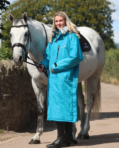 EQUIDRY Evolution Lux Women's Warm Waterproof Winter Horse Riding Coat Thick Fleece Lining with Faux Fur Trim Hood in turquoise rider full front view with horse